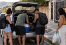 Amigos carregando o porta-malas de um carro antes de sair para uma viagem em grupo
