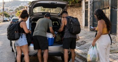 Amigos carregando o porta-malas de um carro antes de sair para uma viagem em grupo